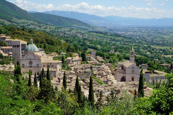 scorcio dall’alto su San Rufino e Santa Chiara immersi nel verde e valle Umbra sullo sfondo.